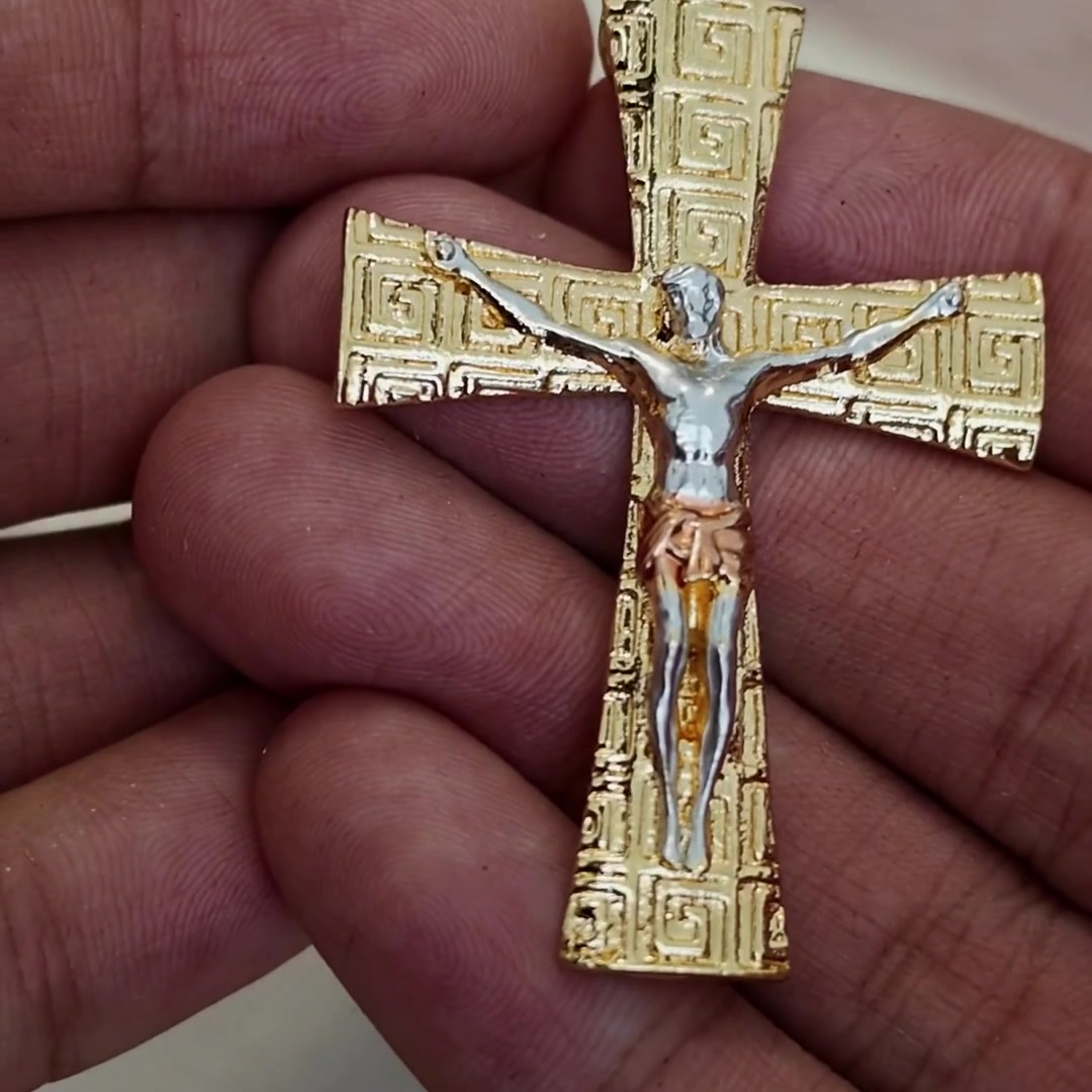 Greek key crucifix pendant in hand, textured gold with two-tone corpus