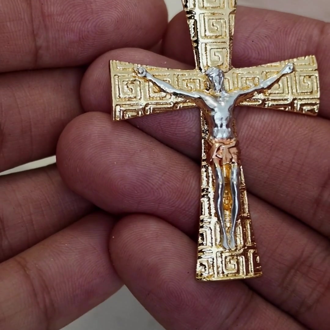 Greek key crucifix pendant, angled view in hand