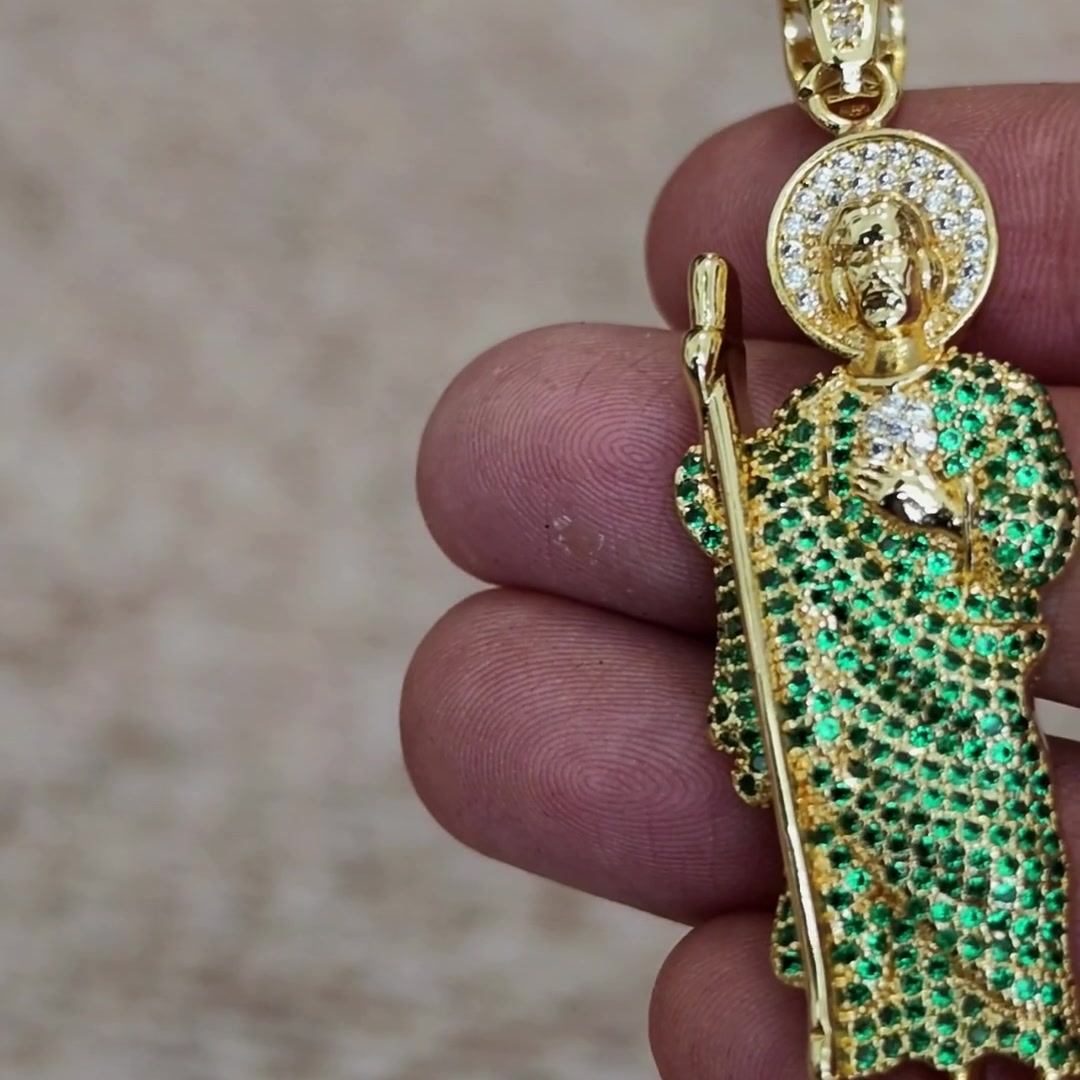 San Judas Tadeo green CZ figure pendant, angled view in hand
