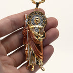 San Judas Tadeo rose gold robe pendant held in hand to show its size