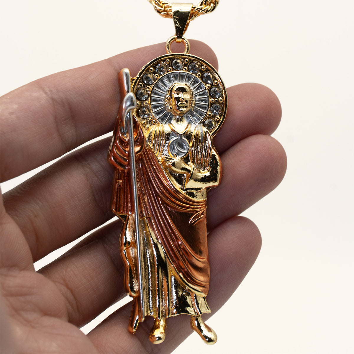 San Judas Tadeo rose gold robe pendant held in hand to show its size