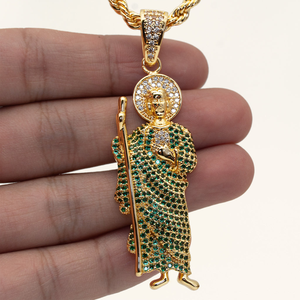 Dije de San Judas Tadeo con circonitas verdes en la mano para mostrar su tamaño