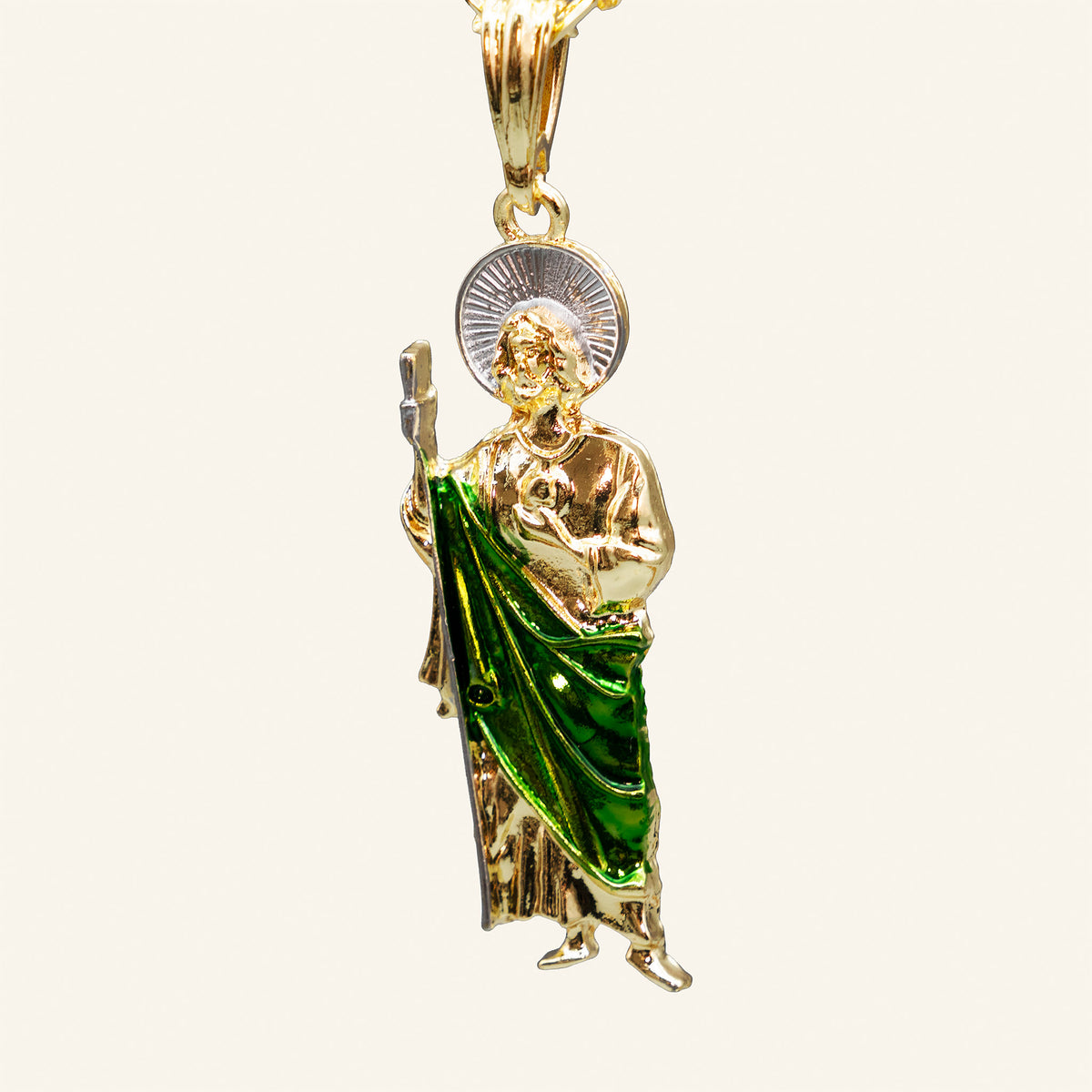 Close-up of San Judas Tadeo pendant with green enamel robe, staff and medallion